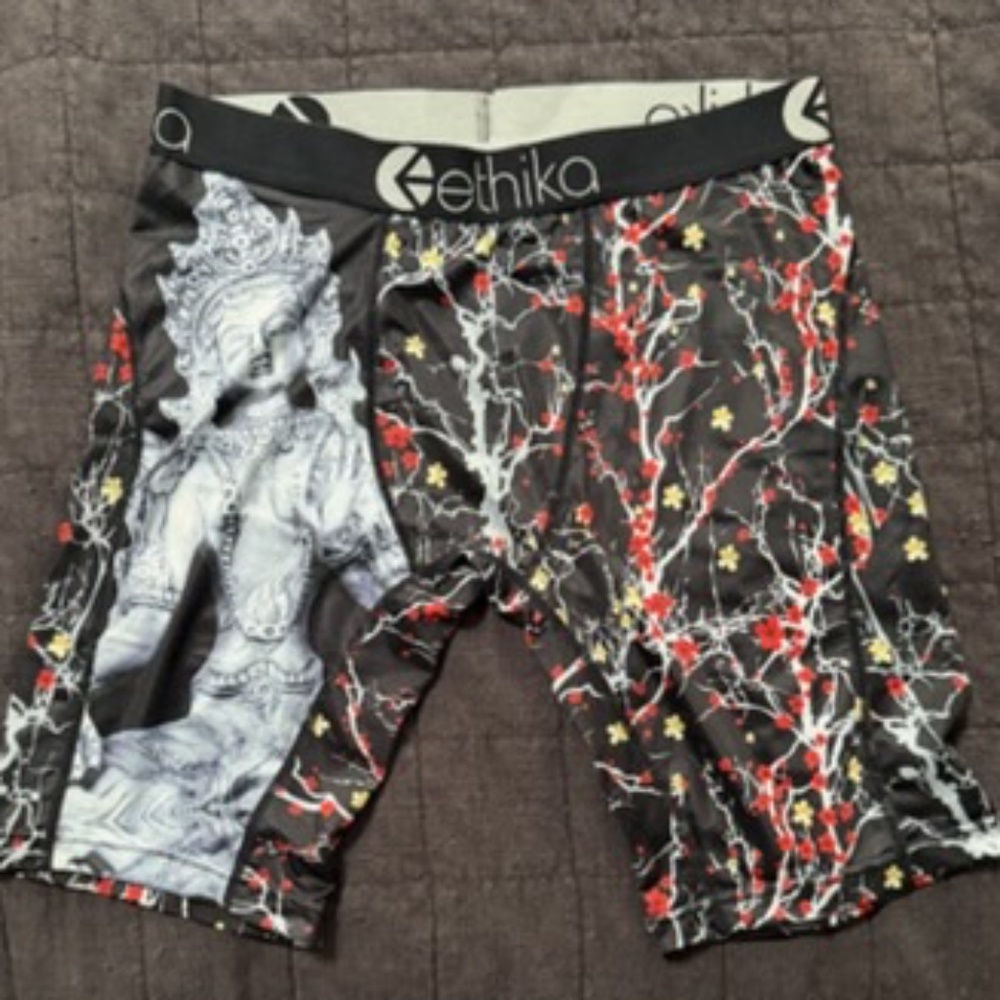 Ethika black background featuring red and white cherry blossom branches MED